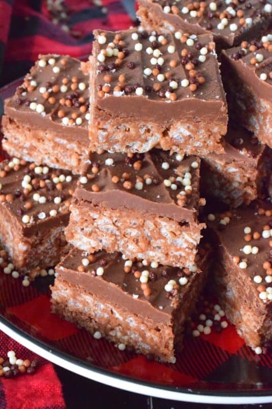 Melted Mars Bars, which consist of caramel, chocolate, and nougat are combined with butter, and rice krispies cereal in these Mars Bar Holiday Squares. Topped with melted milk chocolate and sprinkles, these squares are a no-bake confection that everyone just cannot get enough of! #christmas #holiday #nobake #marsbar #milkyway