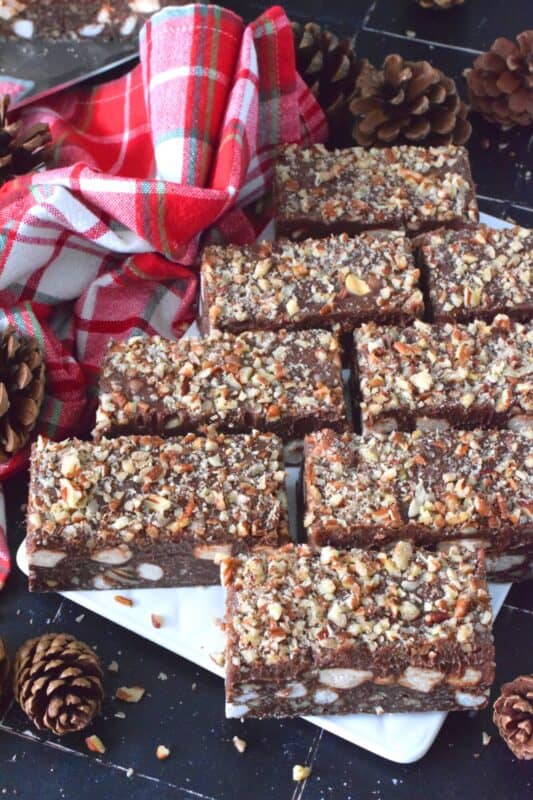 If you're looking for a holiday treat that is both super rich and decadent, Ganache Truffle Bars are just the answer! Marshmallows, toasted pecans, and coconut smothered in a chocolate truffle base is topped with a thick, creamy ganache and more pecans; this luscious and delectable treat is the ultimate Christmas dessert! #truffles #ganache #bars #squares #nuts #marshmallows