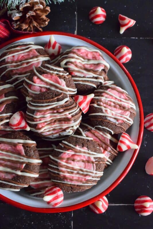 These soft chocolaty Hershey's Peppermint Cookies are baked and then topped with a peppermint kiss as soon as they come out of the oven. Once softened, the kiss is swirled to cover the top of the cookie and then drizzled with melted white chocolate. #peppermint #hershey #kisses #cookies #christmas
