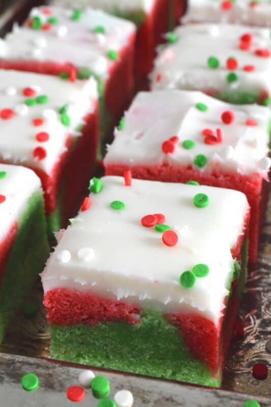 These pillow-soft, beautifully festive red and green Marble Sugar Cookie Bars are going to be on everyone's wishlist this Christmas! The cookie base is buttery and sweet with a light fruity note and topped with a homemade buttercream frosting. One should not question if they will make these; only question whether you will call them bars, squares, cookies, or even cake! #sugarcookies #bars #squares #christmas #holiday #baking #marble #redandgreen