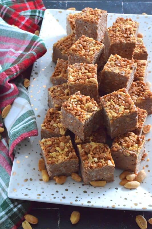 These no-bake bars are super delicious! Prepared with both milk chocolate chips and peanut butter chips, these Peanut Crunch Bars are loaded with crispy rice cereal, toffee bits, and chopped, salted peanuts too! Who needs store-bought treats when you can whip up a batch of these in mere minutes!? #peanutbutter #crunchbars #peanuts #chocolate #nobake #christmas #holiday #bars #squares