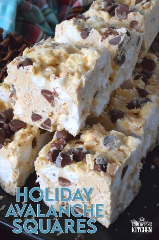 These no-bake treats are prepared with lots of white chocolate, creamy peanut butter, a few cups of rice cereal, and a good helping of marshmallows too. Holiday Avalanche Squares are absolutely delicious! The white chocolate is melted together with the peanut butter, and once cooled, the other ingredients are folded in to create these wonderfully high and cloudy-soft squares! #squares #bars #nobake #christmas #holiday #baking #cookies #chocolate