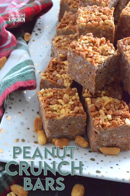 These no-bake bars are super delicious! Prepared with both milk chocolate chips and peanut butter chips, these Peanut Crunch Bars are loaded with crispy rice cereal, toffee bits, and chopped, salted peanuts too! Who needs store-bought treats when you can whip up a batch of these in mere minutes!? #peanutbutter #crunchbars #peanuts #chocolate #nobake #christmas #holiday #bars #squares