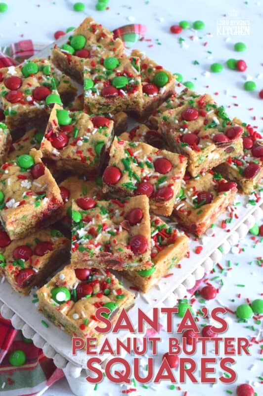 If you want extra presents under the tree this year, leave a couple of these Santa's Peanut Butter Squares with a tall glass of milk on the mantle this Christmas Eve! Loaded with sprinkles, M&Ms, white chocolate chips, peanut butter, and more, who wouldn't want to sink their teeth into this festive treat!? #holidaybars #m&ms #cookies #christmas #baking