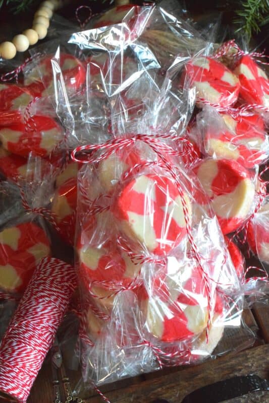 The perfect gift-giving cookie, Peppermint Candy Wheels are individually wrapped in cellophane and tied with a festive string. They may look impressive and maybe even tedious and time consuming, but these cookies really couldn't be easier! And besides, whomever you share these with will certainly appreciate the effort! #peppermint #cookies #candies #redandwhite