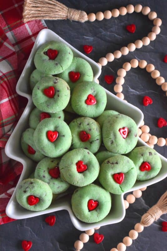 Grinch-themed confections are very popular at Christmastime especially with kids! But, these Sugared Grinch Cookies will appeal to everyone! With a sweet, sugary coating, these thick, puffy cookies are loaded with milk chocolate too! And, despite the fact that the Grinch's heart was small, I've used the biggest red candy heart I could find! #grinch #baking #cookies #christmas #heart