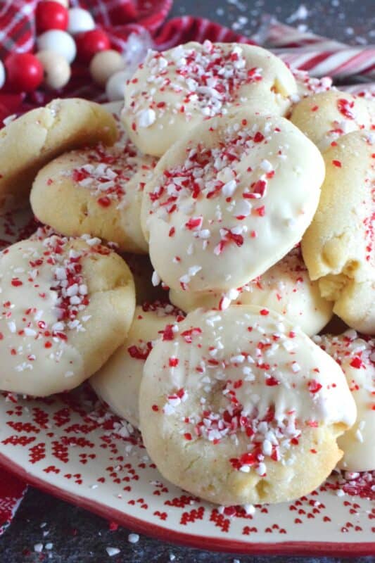 Love the combination of peppermint and chocolate? Who doesn't!? White Chocolate Peppermint Cookies are loaded with peppermint flavour from both the extract and the crushed candy canes. These are not only packed with white chocolate chips, but they're dipped in melted white chocolate too and topped with more crushed candy canes for good measure! #whitechocolate #peppermint #candycane