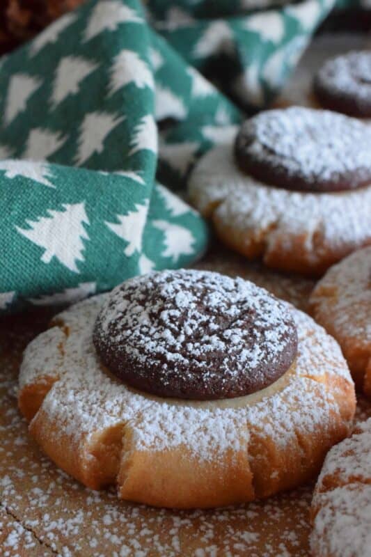 Peanut Meltaway Cookies are a melt-in-your-mouth cookie prepared with peanut butter and topped with a chocolate peanut butter ganache.  Doesn't that sound delicious!?  The base has a shortbread, crumbly-like texture that pairs extraordinarily well with the creaminess of the smooth ganache dollop.  These are simply irresistible! #meltaway #peanutbutter #ganache #cookies