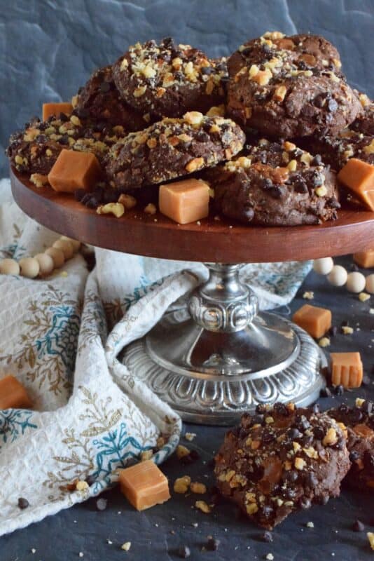 Turtles, turtles, rah, rah, rah! If you remember that jingle and you ate the popular chocolate confection that was popularized by it, then you might enjoy these Holiday Turtle Cookies too! Baked inside and outside of the most delicious chocolate cookie dough are toasted pecans, chocolate chips, and lots of sticky, gooey caramel.  You're going to love this one! #turtles #chocolate #cookies #caramel #pecans