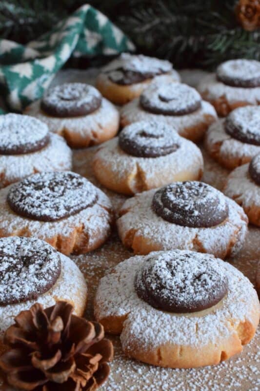 Peanut Meltaway Cookies are a melt-in-your-mouth cookie prepared with peanut butter and topped with a chocolate peanut butter ganache.  Doesn't that sound delicious!?  The base has a shortbread, crumbly-like texture that pairs extraordinarily well with the creaminess of the smooth ganache dollop.  These are simply irresistible! #meltaway #peanutbutter #ganache #cookies