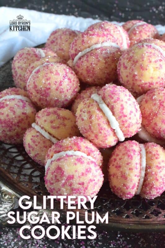 These beautiful, shimmering, Glittery Sugar Plum Cookies are the epitome of priceless luxury on a dollar store budget.The cookies are baked with a sparkling, sugary coating and sandwiched together with an easy, sweet frosting. One bite and you'll certainly have visions of these sugar plums dancing in your head on Christmas Eve night! #sugarplums #christmas #baking #cookies #glitter