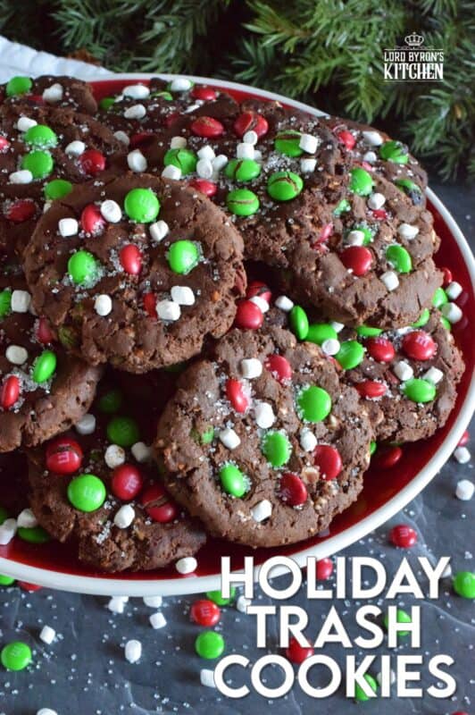 Holiday Trash Cookies are loaded with both milk and white chocolate chips, M&Ms, crushed pretzels, and marshmallow bits too! The cookie dough is prepared with brown sugar, which means these cookies are soft and moist on the inside, but they have a crisp exterior! Make a delightfully tasty gift by packaging these festive cookies up in boxes and tying them with a bright festive ribbon! #mandm #christmas #santa #cookies #trash