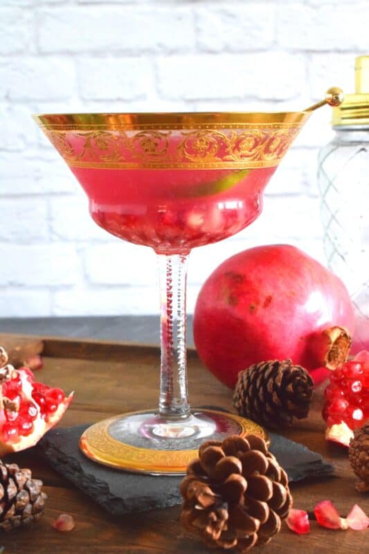This gorgeous cocktail is prepared with gin and pomegranate juice. With a little bit of simple syrup for sweetness and a splash of fresh lime juice, this Festive Pomegranate Martini is full of zing and pizzazz! #christmas #drinks #cocktails