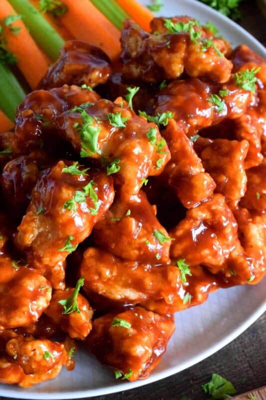 Crispy, fried, battered chicken tossed in your favourite prepared barbecue sauce, Boneless Chicken Bites are a perfect party food. Serve with fresh veggies, dip, and lots of toothpicks. There's no need to get your fingers dirty here! #bonelesschicken #barbecuechicken #BBQ #weeknightrecipes