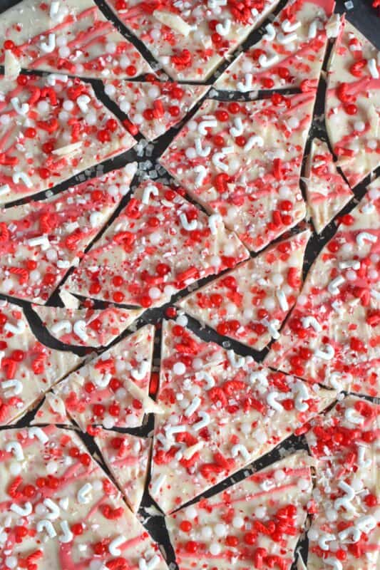 Chocolate bark is the name applied to a thin layer of melted chocolate that has been topped or filled with nuts, cookies, candies, pretzels, etc., and it is supposed to resemble tree bark. Candy Melt Peppermint Bark is prepared with crushed candy canes, peppermint-flavoured white candy melts and lots of festive sprinkles. This sweet treat is quick and easy to make and perfect for gift-giving! #candymelts #peppermint #chocolate #bark