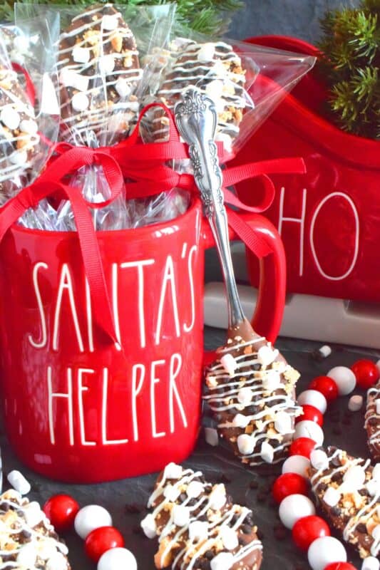 The ultimate rich and indulgent treat can be summed up in three words – S’mores Chocolate Spoons! Melted milk chocolate is topped with classic s'mores ingredients like marshmallows, cookies, and graham crackers. Stir a cup of hot chocolate with one of these spoons while watching your favourite holiday movie! They make a great gift idea too! #smores #stir #spoons