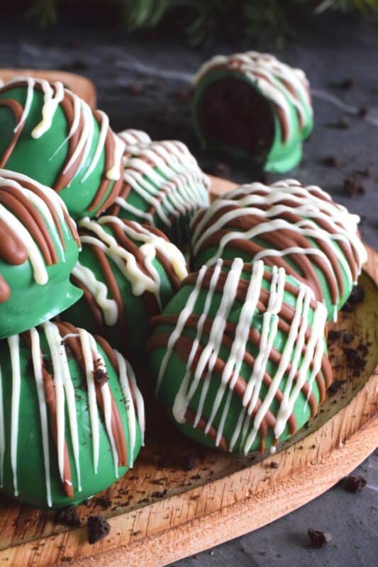 Otherwise known as truffles, these Mint Oreo Balls are prepared with crushed mint-flavoured Oreos and cream cheese. They are dipped in melted green candy melts and drizzled with milk and white melted chocolate. They're bright, beautiful, festive, and delicious! #oreo #truffles #balls #nobake #christmas