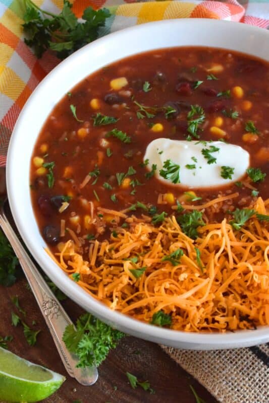 With the help of taco seasoning, canned beans and corn, and some leftover rice, 30 Minute Taco Soup comes together quickly and easily. Make it even better by topping it with cheese, and sour cream! #taco #soup #vegan #vegetable #vegetarian #canned #pantry
