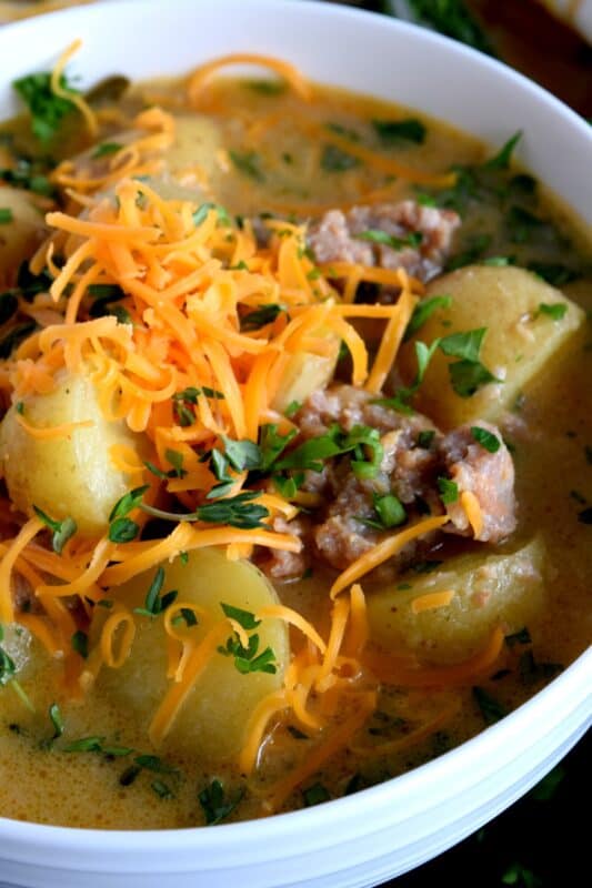 A savoury and hearty chowder which satisfies the cold weather hunger, Italian Sausage and Potato Chowder is flavourful and filling; you're going to love this recipe! Crumbled bacon or shredded cheddar cheese on top (or both!) is a great way to serve this dish! #sausage #italiansausage #chowder #potatosoup #cheese
