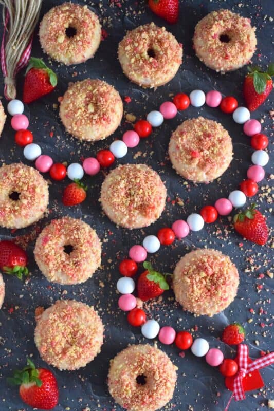 Baked Strawberry Shortcake Donuts are prepared with homemade strawberry shortcake crumbs! Baked to perfection in only 10 minutes, glazed and topped with more shortcake crumbs, these donuts are super soft and moist and very cake-like inside. Share these with your favourite valentine or save them all for yourself! #strawberry #donuts #doughnuts #valentine