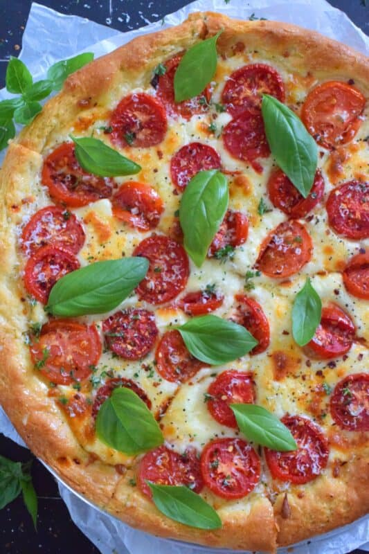One of the best pizza combinations is the Margherita which is simply prepared with sauce, tomatoes, cheese, and basil. Herb and Garlic Margherita Pizza ups the flavour profile with an easy, savoury, homemade pizza dough filled with dried herbs and spices.  You have to try this! #margherita #pizza #homemade