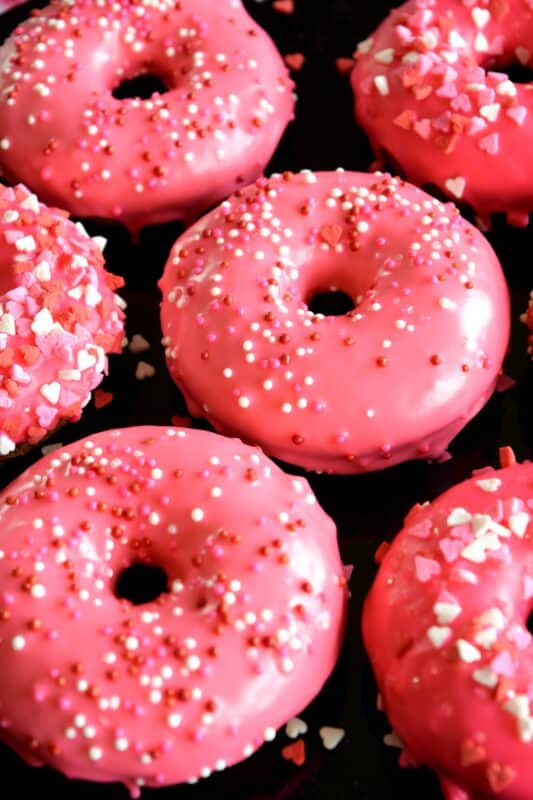 Sour Cream Vanilla Glazed Donuts are baked to perfection in only 10 minutes! They are soft and moist and very cake-like inside. Share these with your favourite valentine or save them all for yourself! #valentines #recipes #pink #donuts #baked
