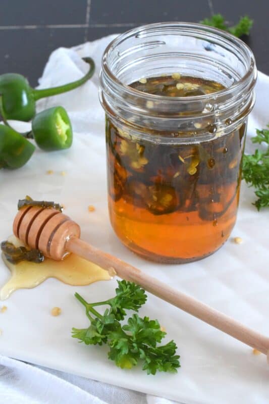 With only two ingredients, this Hot Jalapeno Honey is about to be your new favourite condiment.  Sliced jalapenos are boiled in honey to create a hot and spicy, sticky and sweet drizzling sauce.  Be fair warned, this stuff is so good it's addictive! #jalapeno #honey #hothoney #hotandspicy