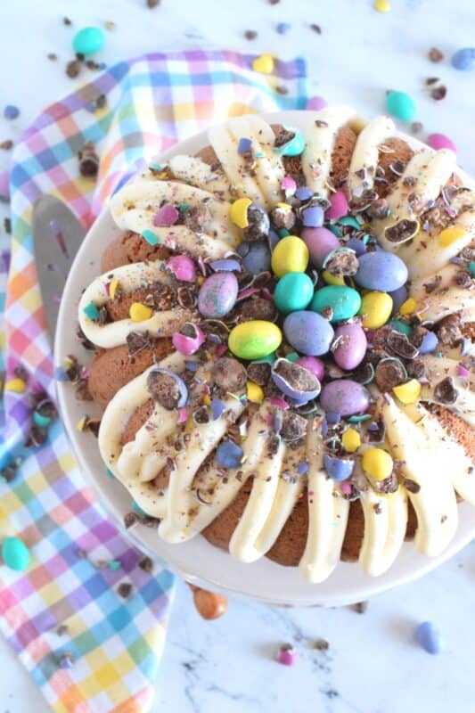 If it's a super moist and fluffy cake recipe you're looking for, look no further!  This Easter Buttermilk Cake is absolutely delicious just as it is, but the cream cheese frosting, which is prepared with buttermilk as well, makes this cake taste extraordinary!  Loaded up with chocolate eggs, this cake is sure to delight and impress! #bundtbakers #easter #buttermilk #cake #bundt