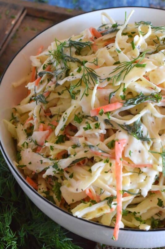If you love dill, this Creamy Dill Pickle Coleslaw is for you! Slightly sweet and tangy, it is packed with lots of dill pickle flavour. In this recipe, there are three layers of dill flavour. There's lots of fresh dill, dill pickle juice, and finely chopped dill pickles. Is your mouth watering yet? #dillpickle #coleslaw #creamycoleslaw #pickles #salad