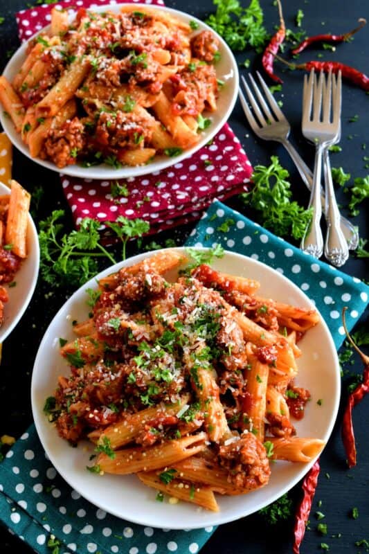Prepare your next pasta dish with pork, like this Spicy Sausage Pasta dish, and reinvent pasta night! A spicy tomato sauce, with peppers and onions, and lots of dried chillies, is simple and rustic, but so delicious! This hearty meal is make-ahead and freezer friendly too! #penne #pasta #italian #sausage #spicy