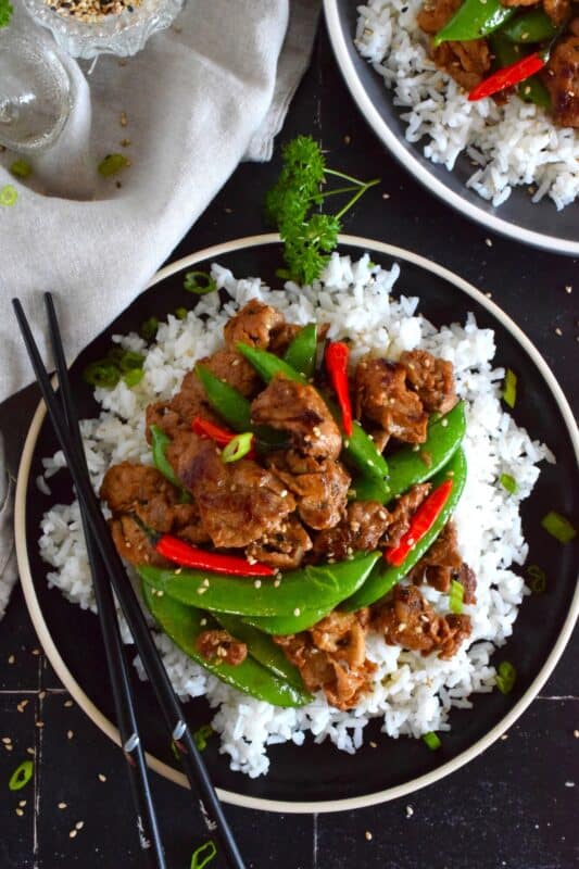 Marinate the pork ahead of time and prepare dinner in about ten minutes flat with this Japanese Ginger Fried Pork recipe.  Made with red bell peppers and snow peas, serve over steamed rice for a completely nutritious meal! #pork #japanese #asianfood #stirfry #ginger