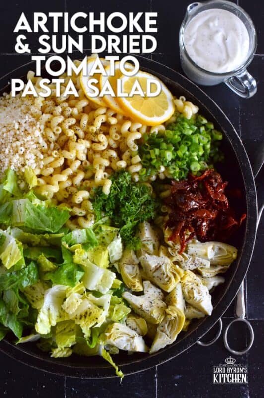 Prepared with pasta, lettuce, canned artichokes, chopped sun-dried tomatoes, onions, and parmesan, this salad can be a delicious side or a complete meal! The hot and hazy days of summer are just weeks away, so save this recipe now for your backyard barbecues and those family picnics! #sundried #tomato #pasta #salad #artichoke