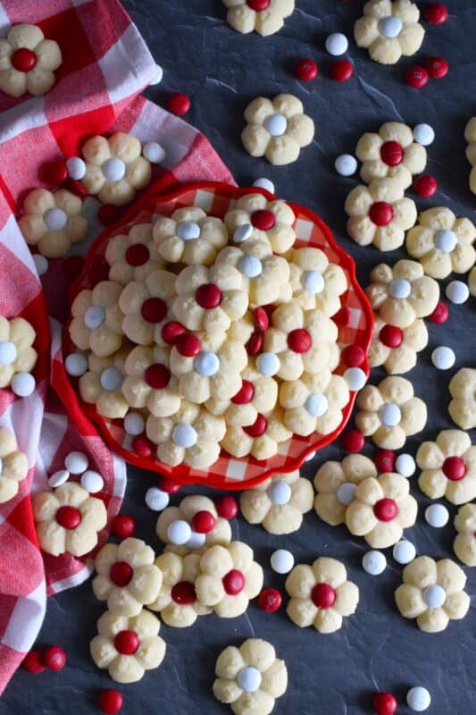 This recipe combines two very popular types of cookies – a spritz cookie and a thumbprint cookie! The base is slightly sweet and buttery and is perfectly paired with a single candy-coated chocolate. These are slightly crumbly, but not dry, and paired with a red or white M&M candy, these cookies are delicious! #redandwhite #canadaday #cookies #spritz
