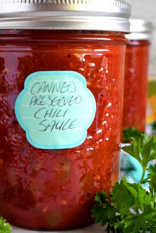 Always have a great tasting chili with deep flavour on hand with this Canned Chili Sauce recipe. Just add beans and simmer! But, that's not all; heat the sauce and ladle it over baked potato, or over fries topped with shredded cheese. So many possibilities when you have pantry stocked with this sauce! #canned #preserved #chili #sauce #tomatoes