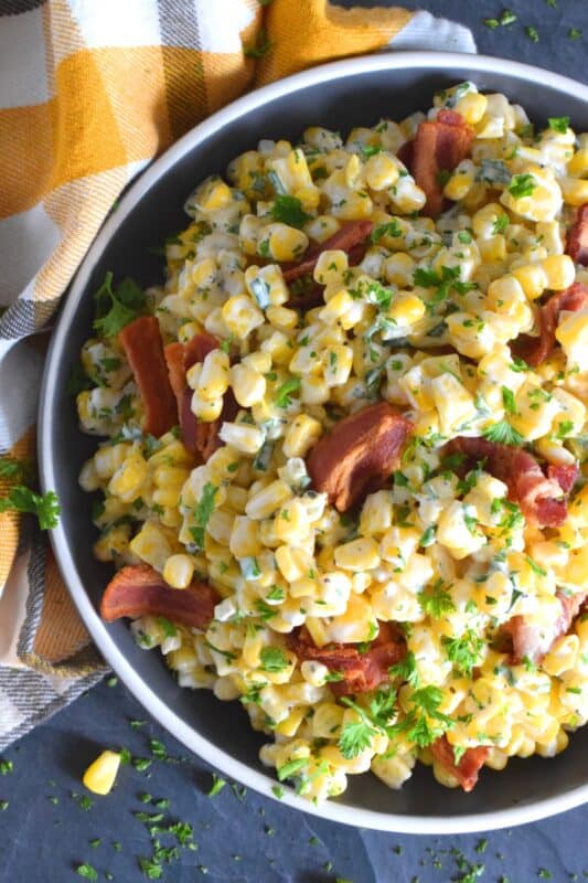 Serve this Bacon and Corn Salad warm as a side to your favourite summer grilled mains. Loaded with fried bacon, bright yellow corn, and fresh green onions, this salad is tossed with a kicked-up mayonnaise-based dressing. Can be prepared ahead of time too and just lightly reheated through just before serving! #bacon #corn #salad
