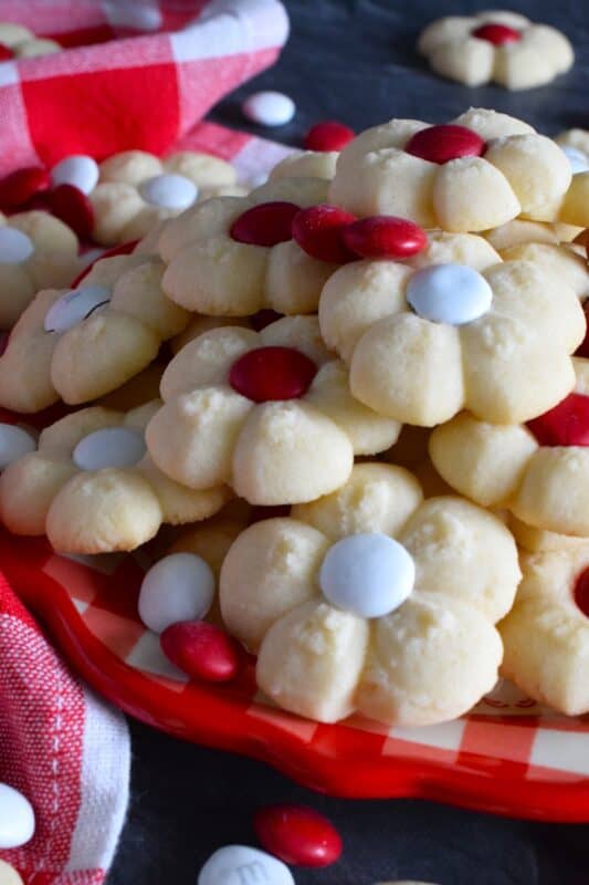 This recipe combines two very popular types of cookies – a spritz cookie and a thumbprint cookie! The base is slightly sweet and buttery and is perfectly paired with a single candy-coated chocolate. These are slightly crumbly, but not dry, and paired with a red or white M&M candy, these cookies are delicious! #redandwhite #canadaday #cookies #spritz