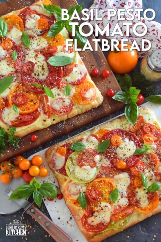 Freshly sliced tomatoes and cheese are piled onto a quick and easy homemade flatbread with the best double parmesan basil pesto sauce. Baked to perfection and topped with fresh basil leaves and ground black pepper, this is a very scrumptiously delicious recipe! #tomatoes #flatbread #heirloom #summerfresh