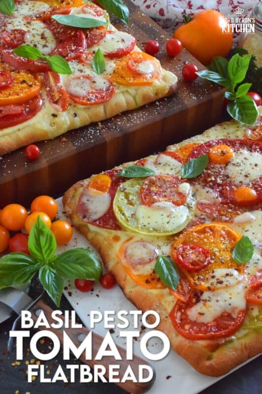 Freshly sliced tomatoes and cheese are piled onto a quick and easy homemade flatbread with the best double parmesan basil pesto sauce. Baked to perfection and topped with fresh basil leaves and ground black pepper, this is a very scrumptiously delicious recipe! #tomatoes #flatbread #heirloom #summerfresh