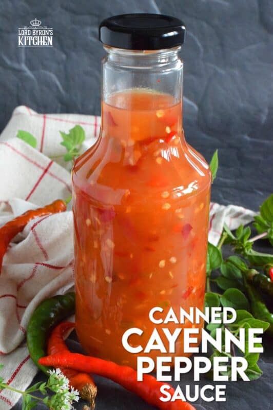This hot and spicy sauce is not super hot, especially not in smaller amounts. Making good use of the last of the peppers before the frost hits is what this recipe was made for. Flecked with both red and green chilies, this sauce has so many uses! Prepared with vinegar, garlic, sugar, and salt, the flavour profile is complex and layered! #cayenne #pepper #sauce #canning #waterbath