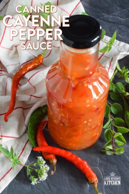 This hot and spicy sauce is not super hot, especially not in smaller amounts. Making good use of the last of the peppers before the frost hits is what this recipe was made for. Flecked with both red and green chilies, this sauce has so many uses! Prepared with vinegar, garlic, sugar, and salt, the flavour profile is complex and layered! #cayenne #pepper #sauce #canning #waterbath