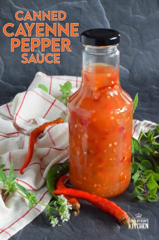 This hot and spicy sauce is not super hot, especially not in smaller amounts. Making good use of the last of the peppers before the frost hits is what this recipe was made for. Flecked with both red and green chilies, this sauce has so many uses! Prepared with vinegar, garlic, sugar, and salt, the flavour profile is complex and layered! #cayenne #pepper #sauce #canning #waterbath