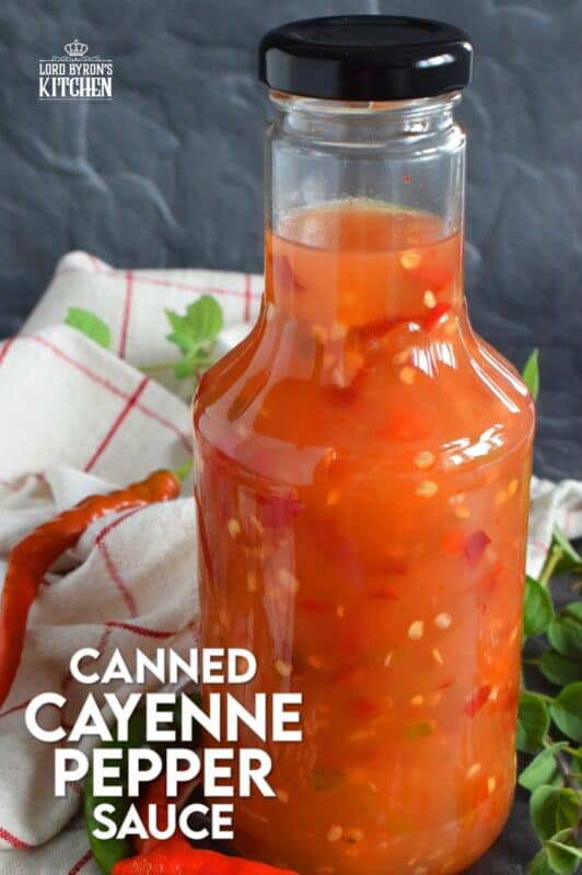 This hot and spicy sauce is not super hot, especially not in smaller amounts. Making good use of the last of the peppers before the frost hits is what this recipe was made for. Flecked with both red and green chilies, this sauce has so many uses! Prepared with vinegar, garlic, sugar, and salt, the flavour profile is complex and layered! #cayenne #pepper #sauce #canning #waterbath