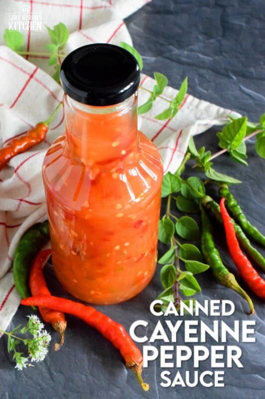 This hot and spicy sauce is not super hot, especially not in smaller amounts. Making good use of the last of the peppers before the frost hits is what this recipe was made for. Flecked with both red and green chilies, this sauce has so many uses! Prepared with vinegar, garlic, sugar, and salt, the flavour profile is complex and layered! #cayenne #pepper #sauce #canning #waterbath