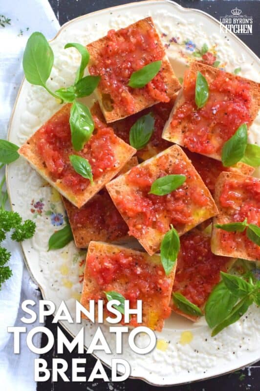 Summer fresh tomatoes are peeled and mashed and spread onto warm, toasted bread that has been rubbed with whole garlic cloves. Seasoned with ground black pepper and flaked sea salt, and a splash of olive oil, Spanish Tomato Bread is a popular tapas bar recipe! #catalan #spanish #tomato #bread