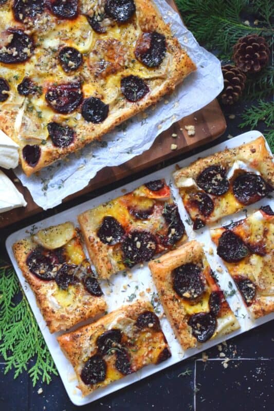 The combination of roasted beets, walnuts, and cheese is unbeatable! This Savoury Brie and Beet Tart has all three of those ingredients baked on a light and fluffy puff pastry, drizzled with honey, and topped with fresh herbs. It's hard to eat just one slice! #beets #brie #cheese #tart #appetizer #holiday
