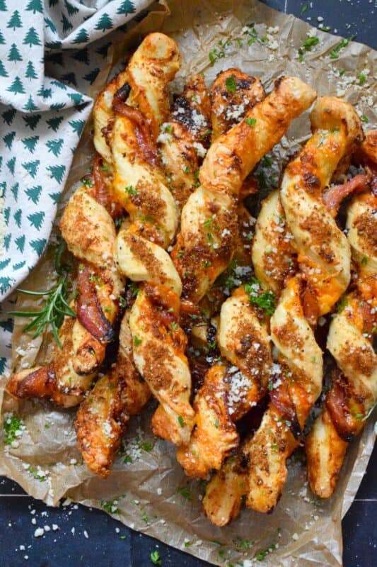 This appetizer consists of salty bacon twisted around light and airy, buttery puff pastry with shredded cheddar cheese all in brown sugar, thyme, oregano, garlic, onion, and ground black pepper seasoning! Words do not exist to describe how wonderfully delicious these are! #bacon #puffpastry #cheesy #appetizer