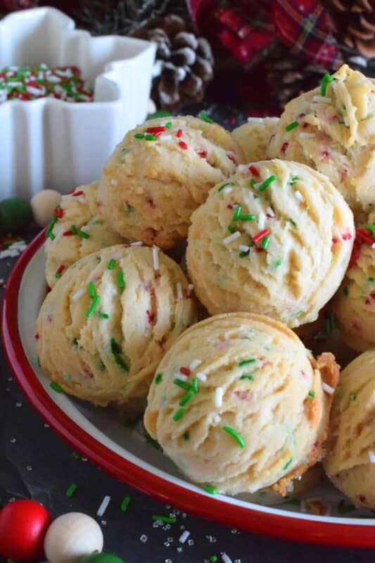 A holiday cookie platter must always have a cookie that is packed with sprinkles and these Funfetti Snowball Cookies fit the bill quite nicely! These are puffy, rounded cookies that require only a few of the most basic pantry ingredients, yet they look and taste amazing! #funfetti #christmas #cookies #sprinkles