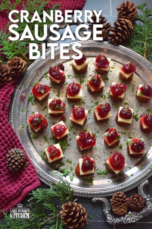 Oven-roasted smoked sausage is topped with a slice of aged cheddar cheese and dressed with cranberries. The big-bite combination of salty sausage, and creamy cheese, with sweet and bitter cranberries, is delightful! #cranberry #sausage #appetizer #holiday #christmas