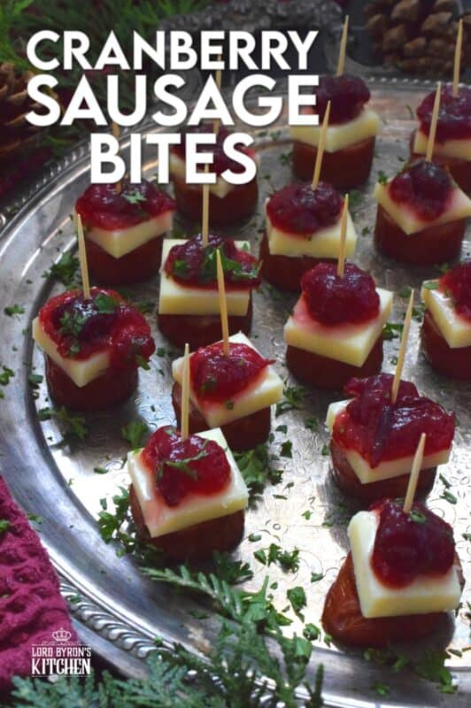 Oven-roasted smoked sausage is topped with a slice of aged cheddar cheese and dressed with cranberries. The big-bite combination of salty sausage, and creamy cheese, with sweet and bitter cranberries, is delightful! #cranberry #sausage #appetizer #holiday #christmas