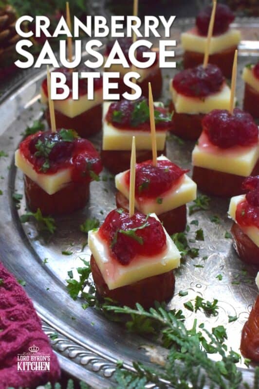 Oven-roasted smoked sausage is topped with a slice of aged cheddar cheese and dressed with cranberries. The big-bite combination of salty sausage, and creamy cheese, with sweet and bitter cranberries, is delightful! #cranberry #sausage #appetizer #holiday #christmas